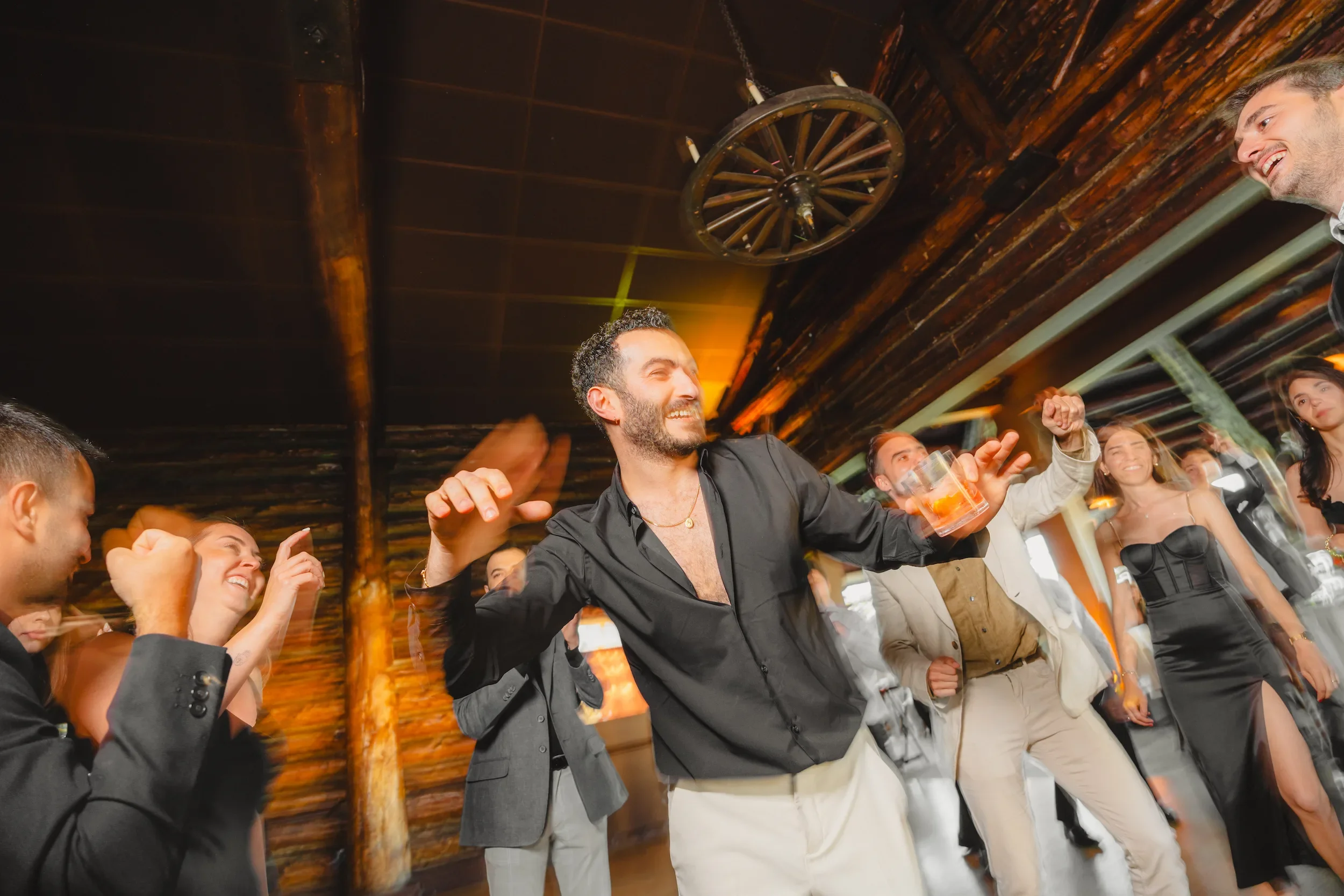 Group of people dancing and having fun at a party or celebration indoors.