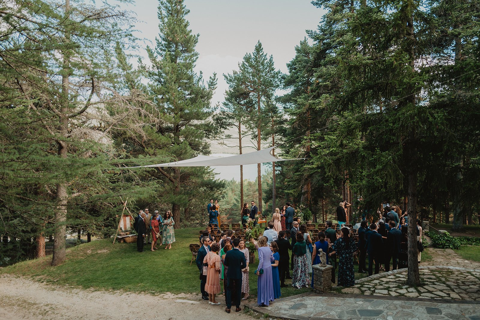Grupo de personas reunidas en un claro del bosque, preparándose para una ceremonia al aire libre.
