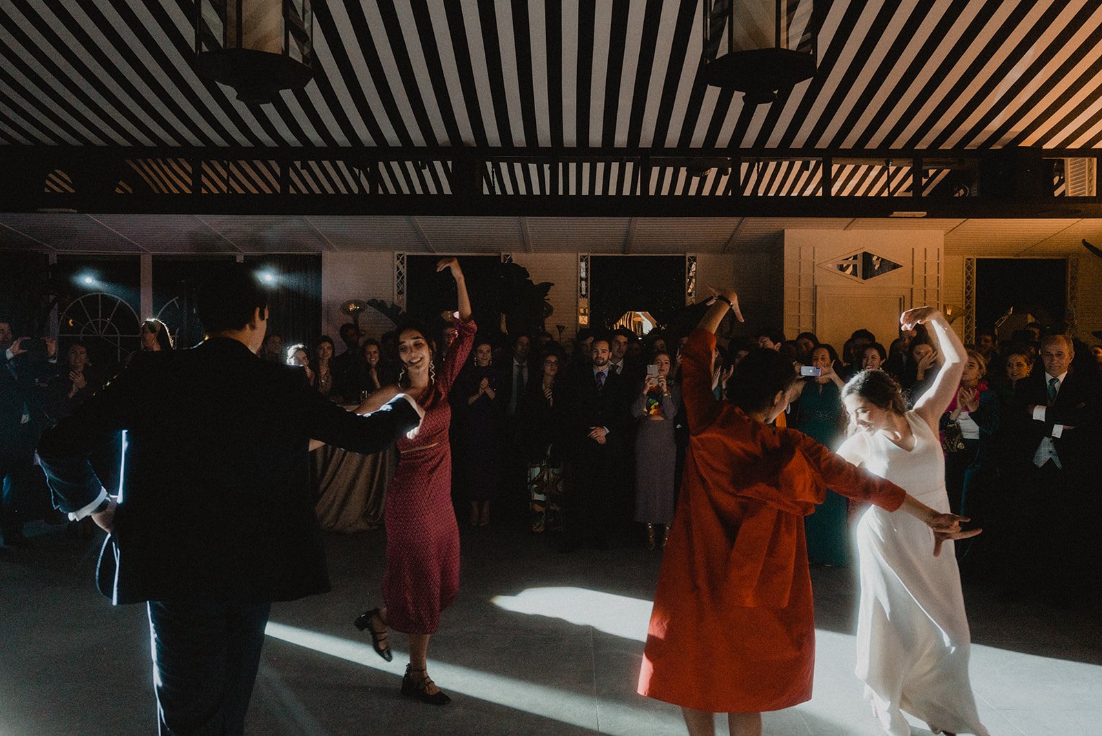 Personas bailando flamenco en un evento con público observando.