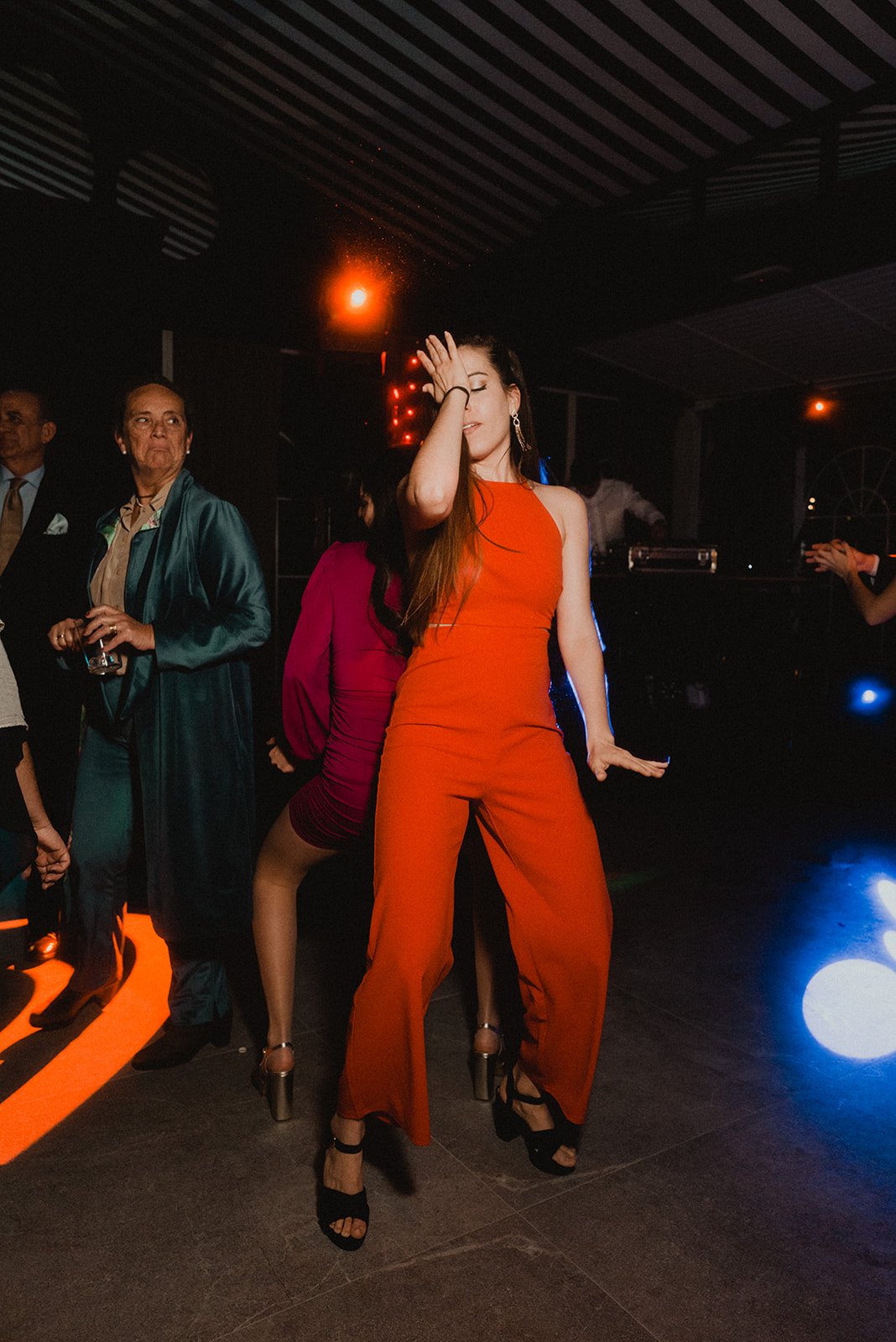Personas bailando en una fiesta con luces de discoteca.