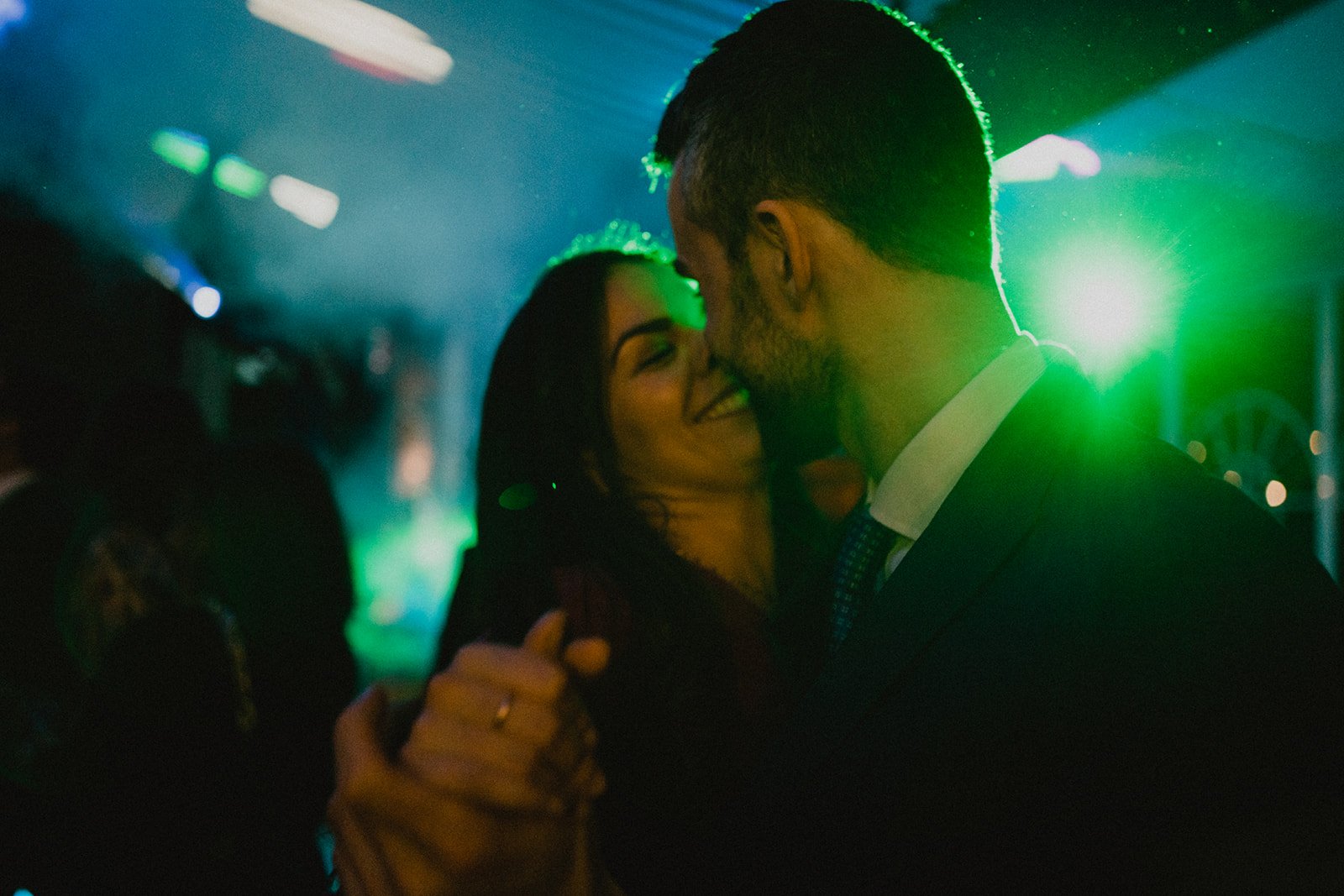 Pareja bailando en una fiesta con iluminación verde.