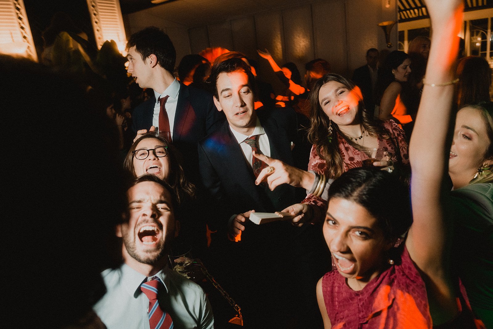 Grupo de personas bailando y divirtiéndose en una fiesta, con luces de colores y ambiente alegre.