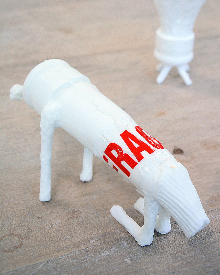 Slip cast porcelain milk cluster, cast found objects and plastic tape.