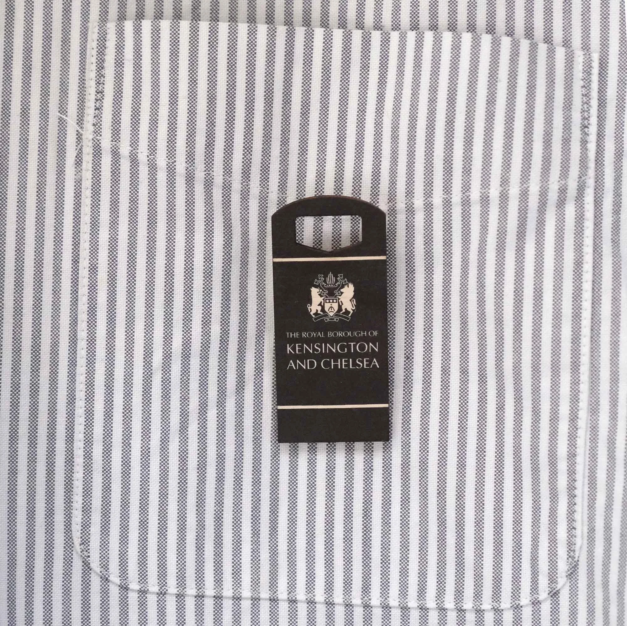 Kensington and bin badge on a stripy shirt pocket
