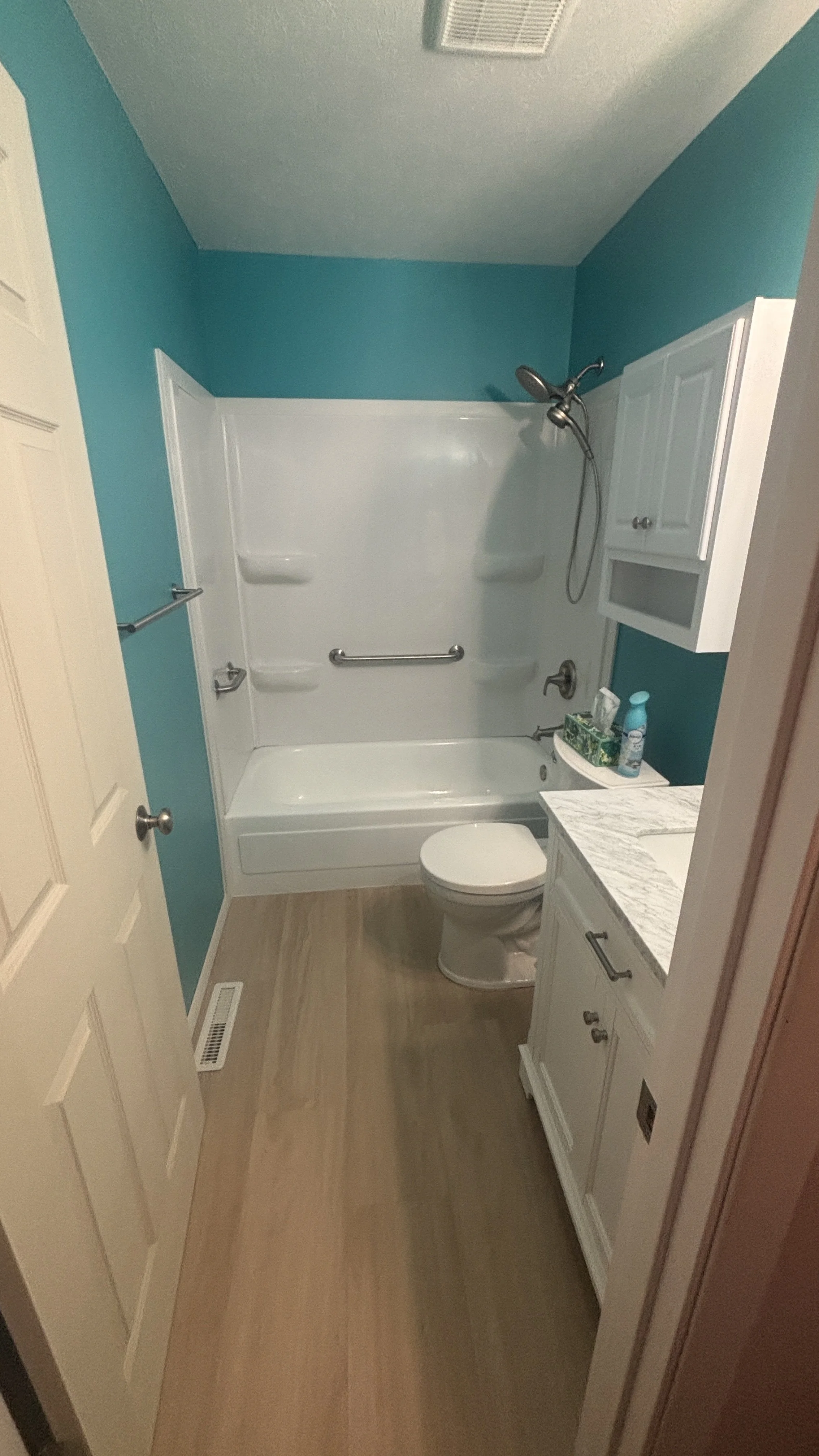 before and after new tub surround grab bars handyman bathroom updates remodel vanity flooring