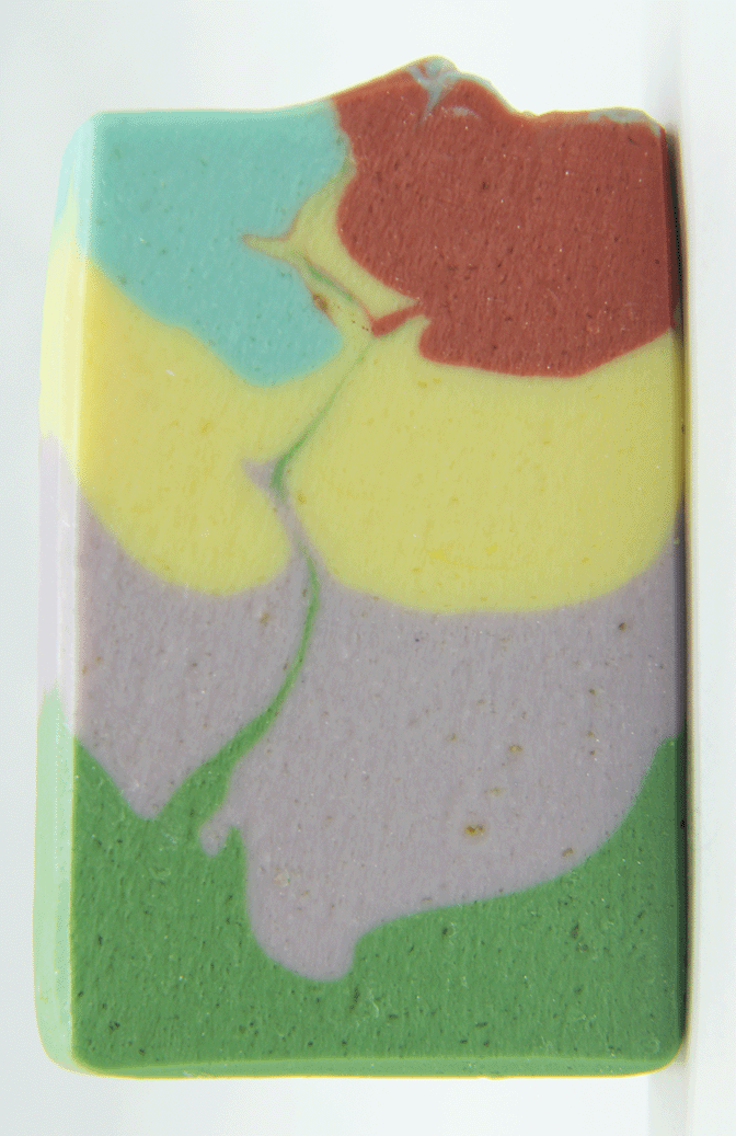 Close up of a Spring Collection soap bar showing swirled layers of green, lavender, yellow, red, and blue in a handcrafted goat milk soap