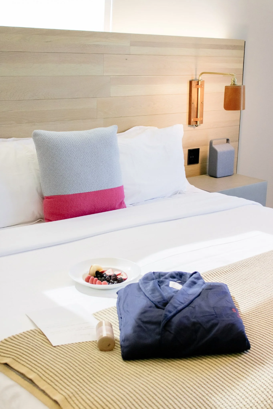 Blue Robe on a Bed at Hotel SLO with fruit bowl and welcome note