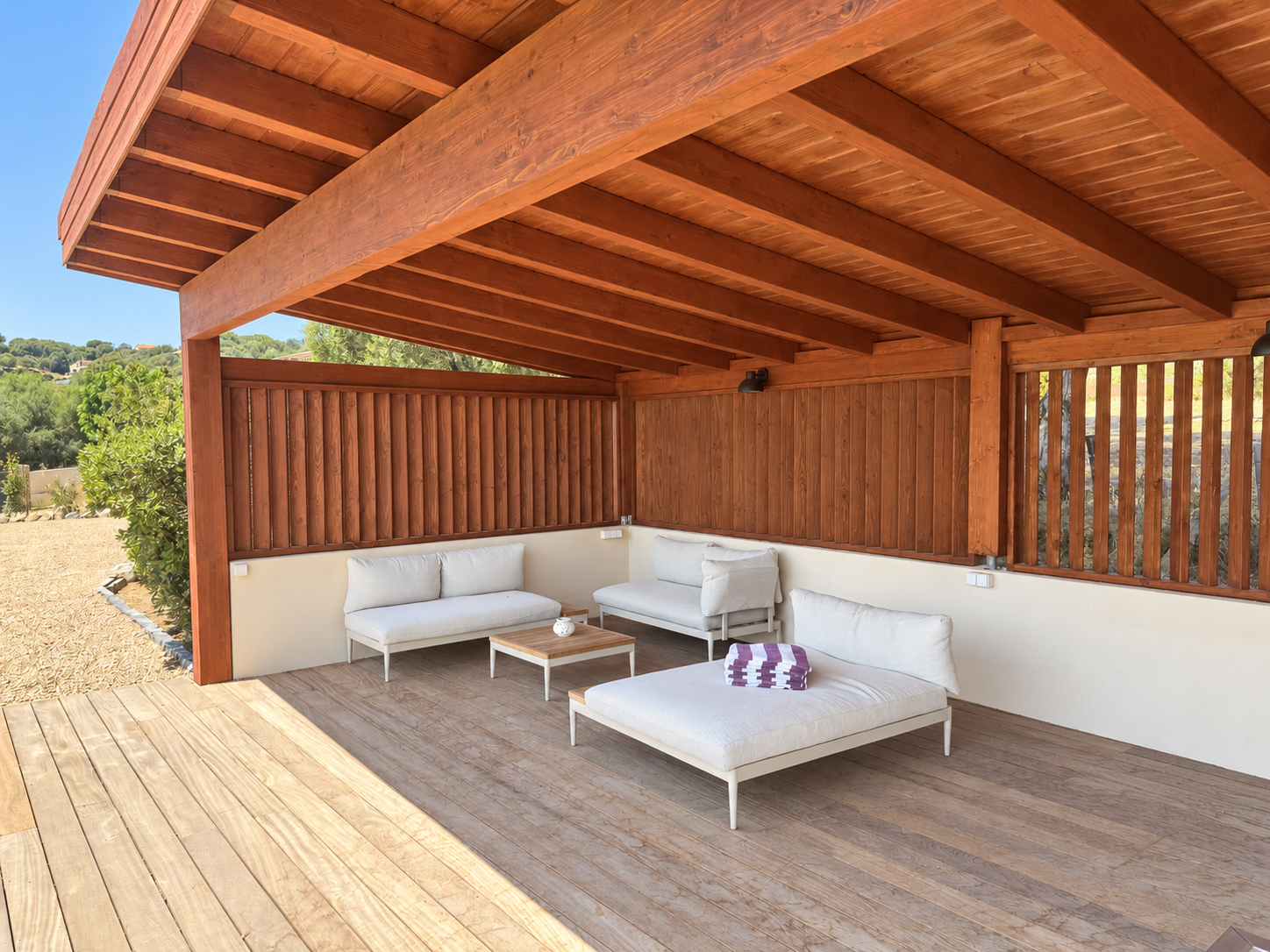 Salon extérieur lumineux sous abri en bois.png