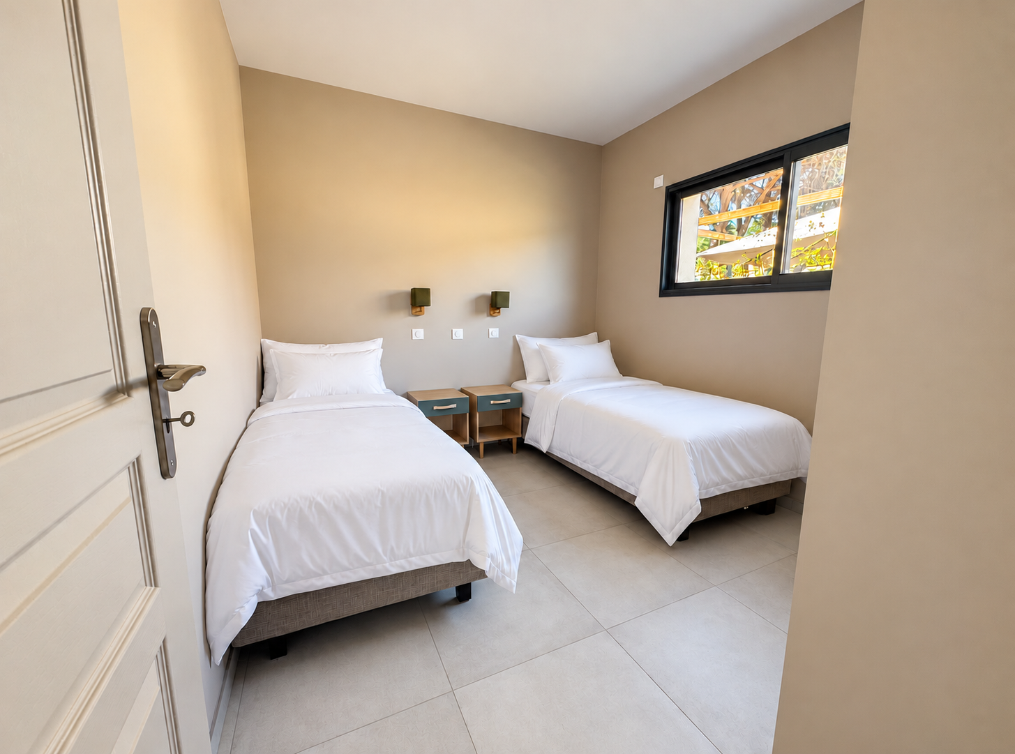 Chambre lumineuse aux deux lits blancs.png
