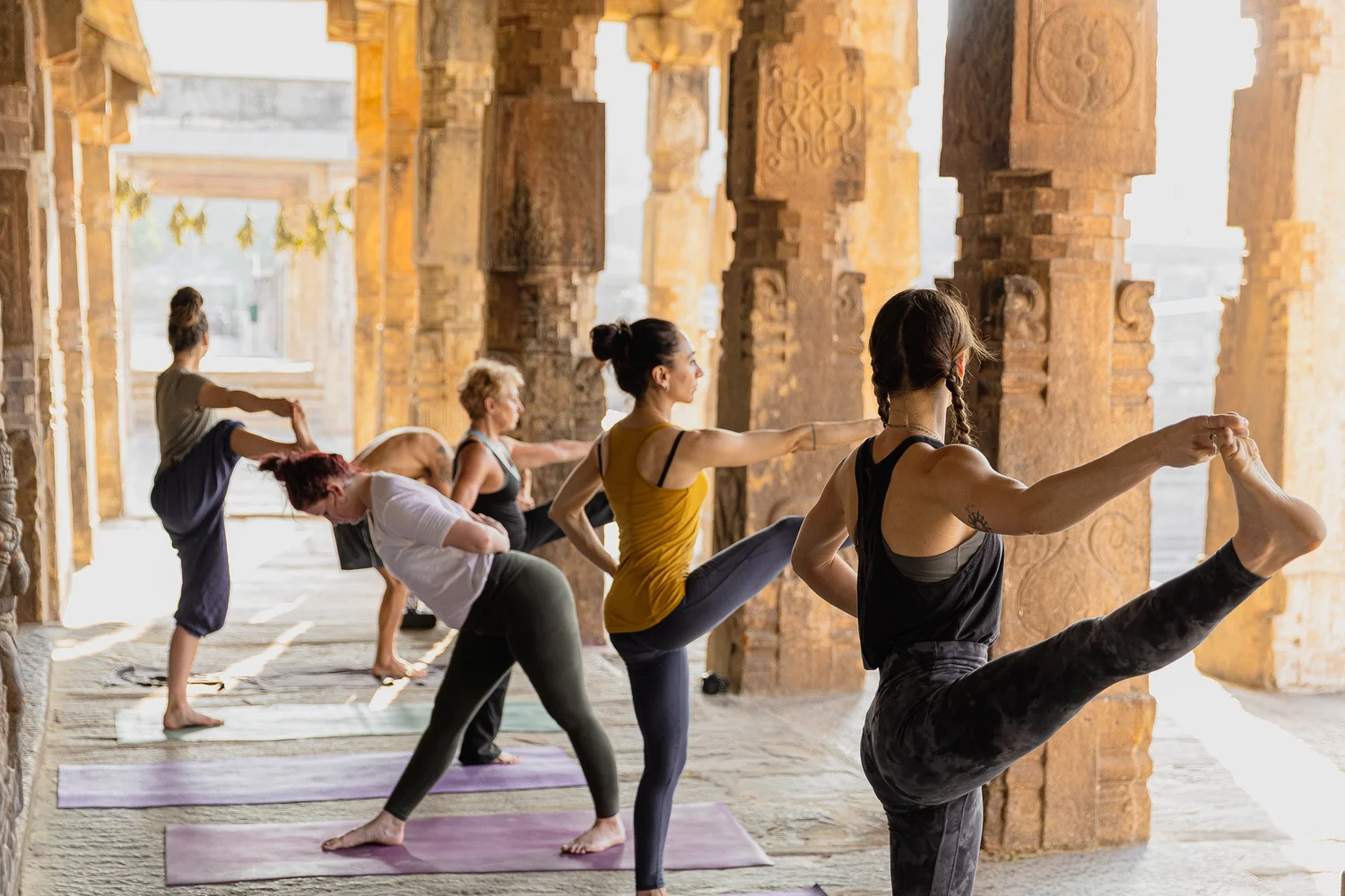 Practitioners standing together at a temple in Melkote at sunrise