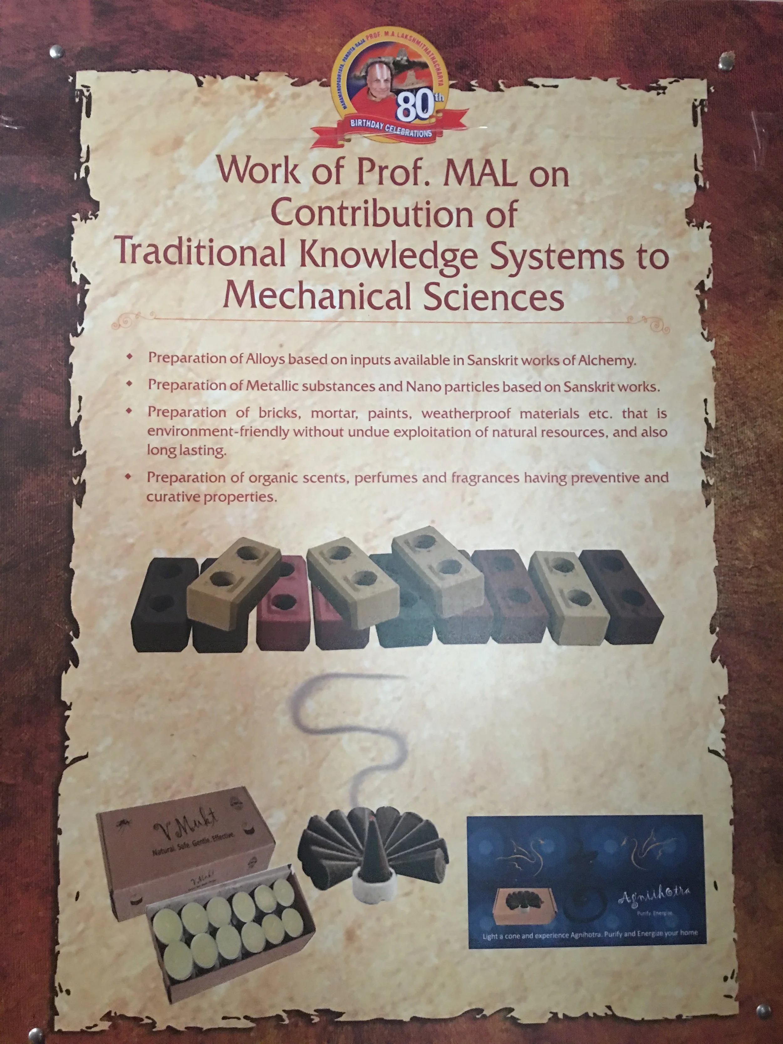 Exhibition panel on Prof. M. A. Lakshmithathacharya's work applying traditional Sanskrit knowledge systems to mechanical sciences: alloys and nanoparticles from Sanskrit alchemy texts, eco-friendly bricks and paints, and organic perfumes