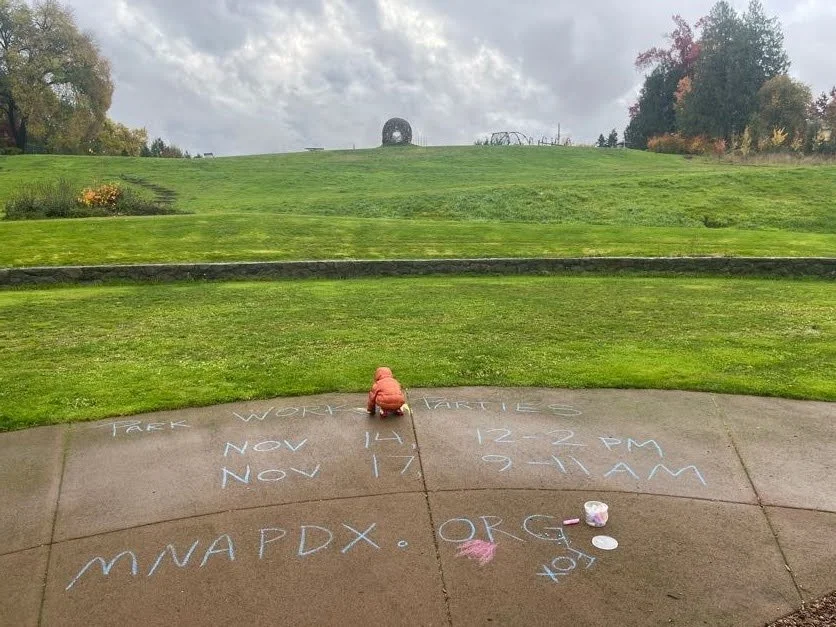 Child drawing with chalk art in park.