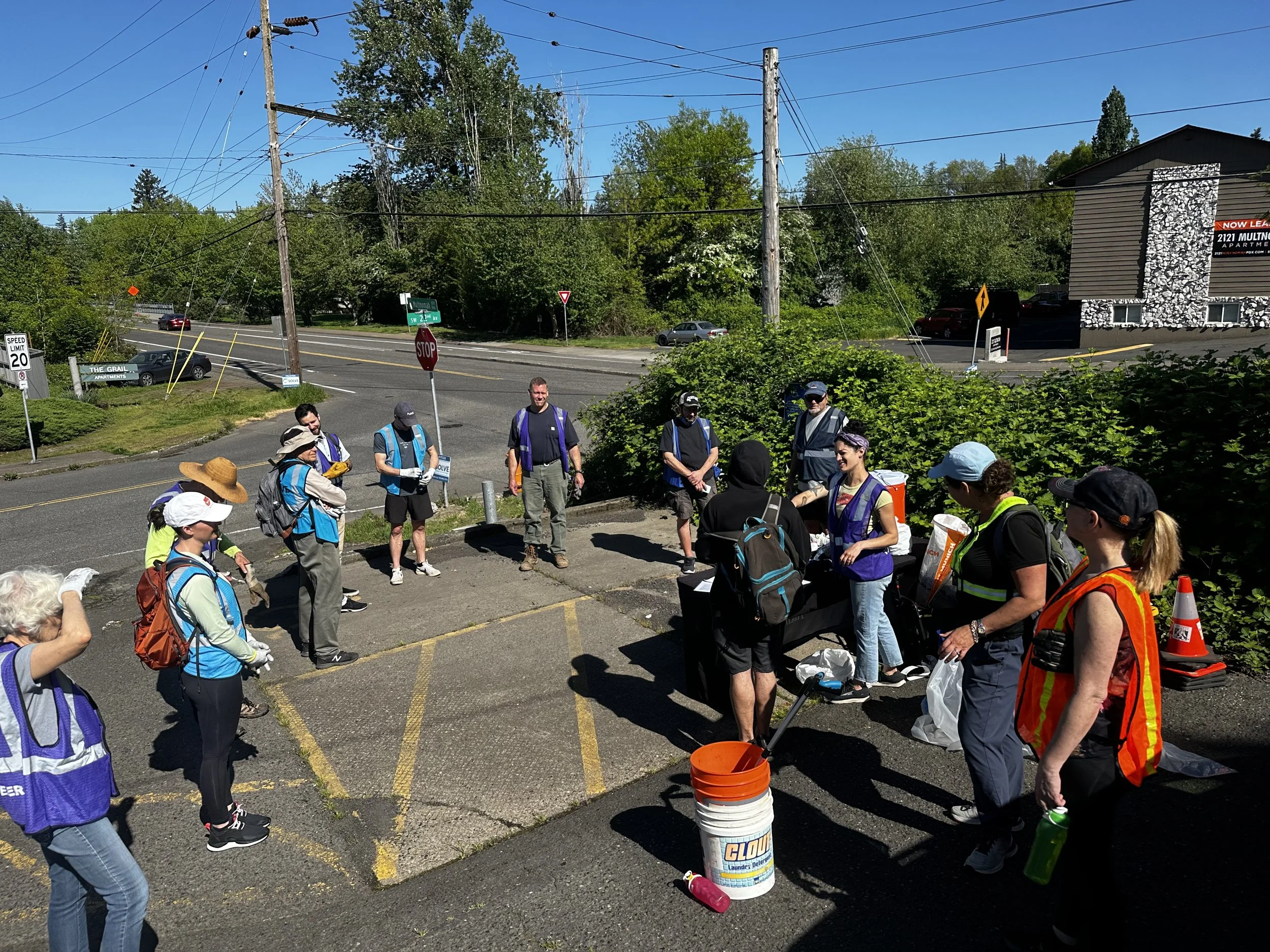 Volunteers standing in a circle, wearing vests