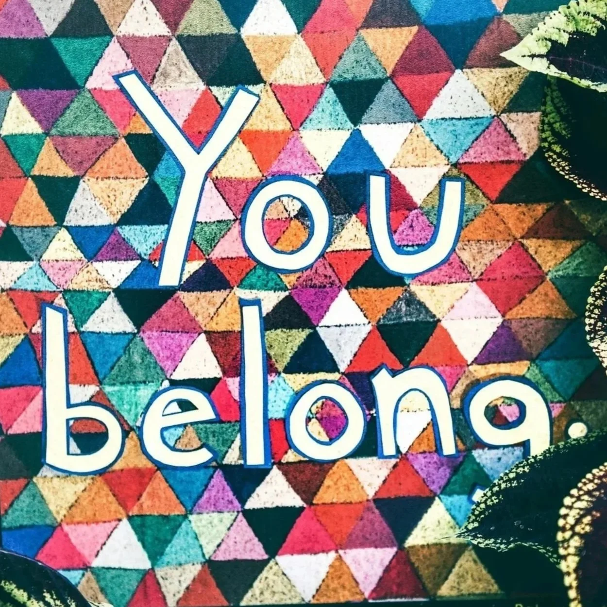 Colorful geometric patterned fabric with the phrase 'You belong.' written in large, white, outlined letters.