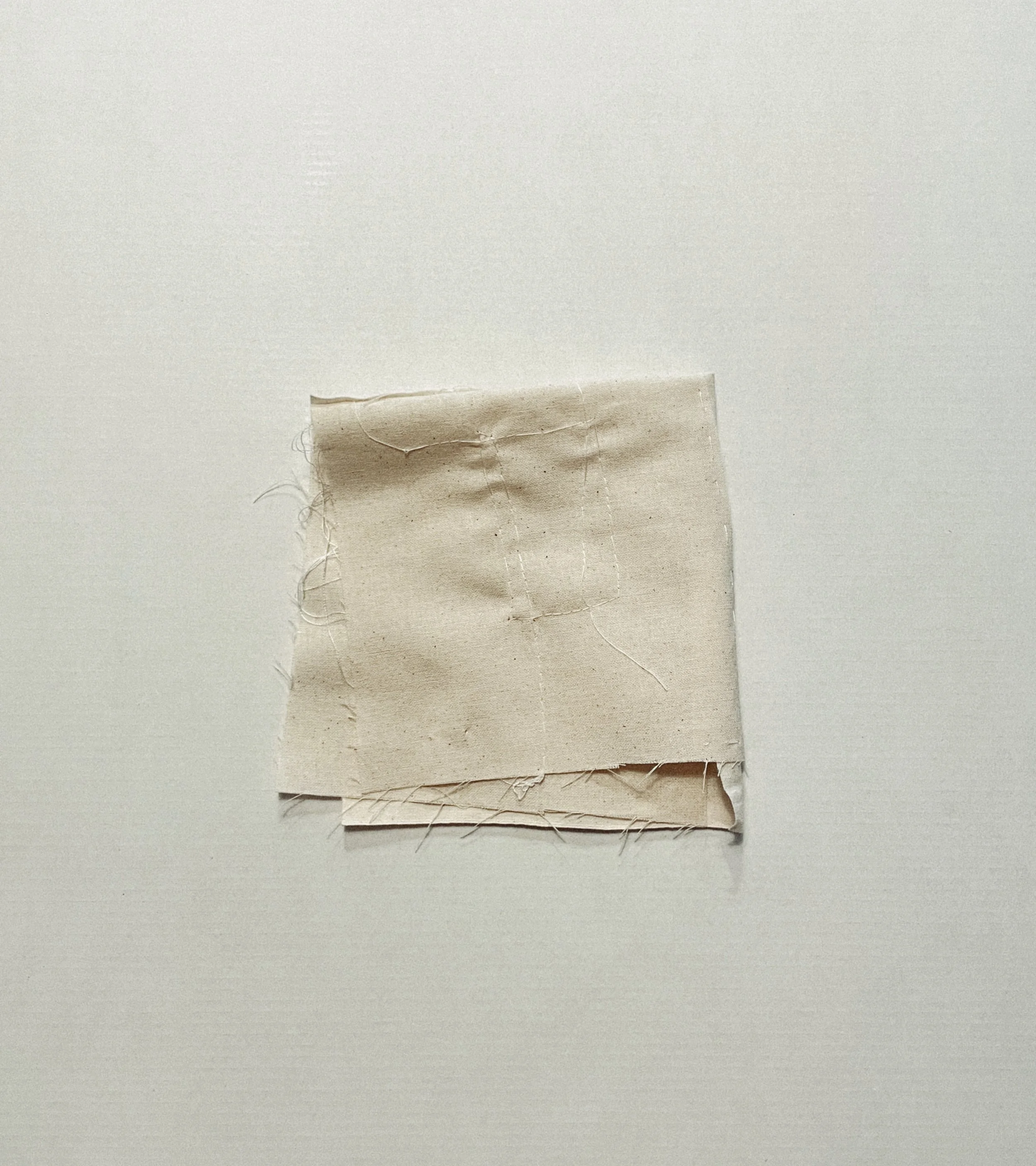 Off-White hand-stitched cloth folded into a small layered form.