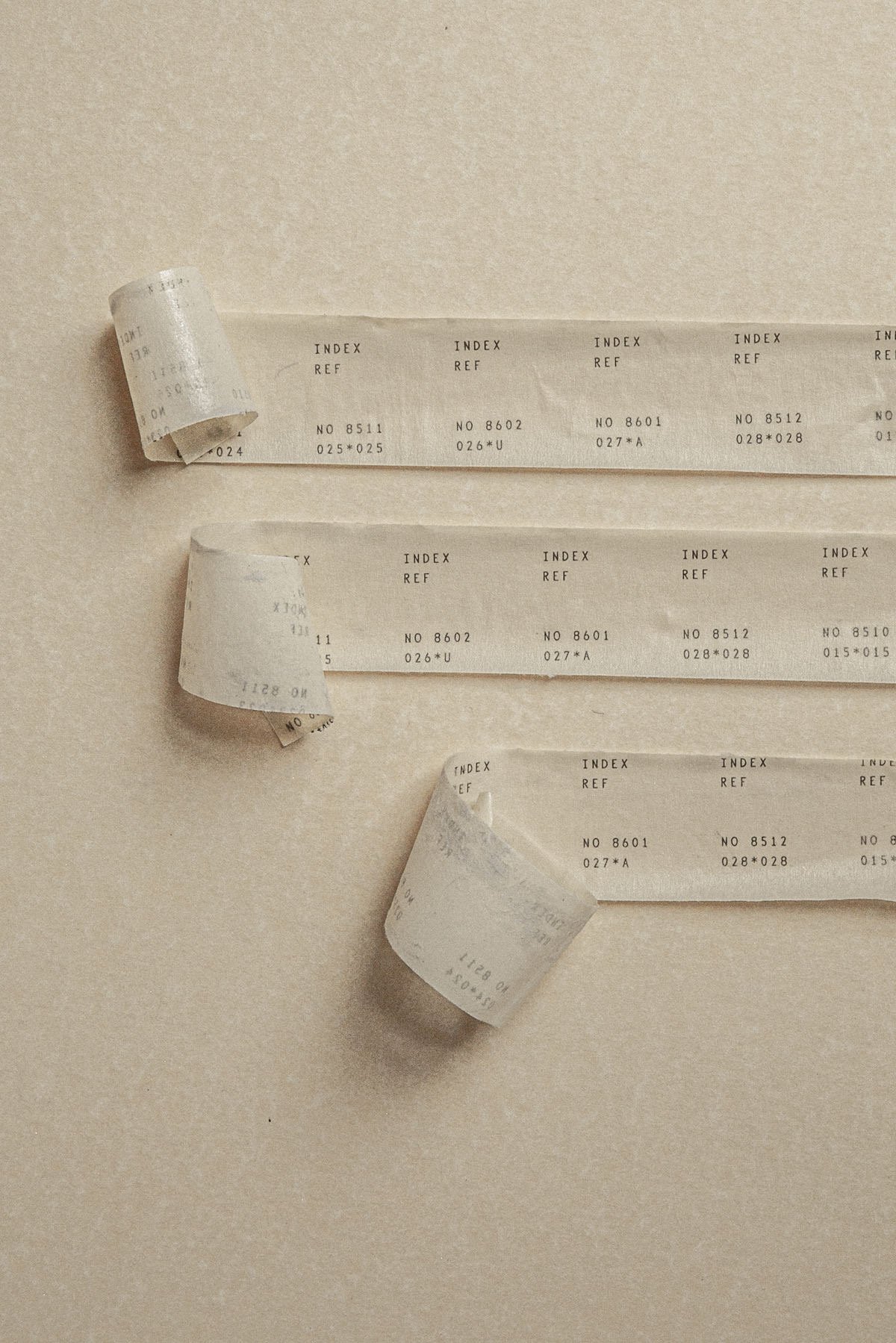 Paper index labels with reference numbers, arranged like an archive index on a neutral surface.