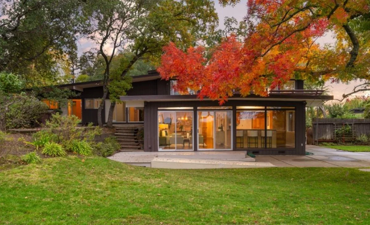 Lovely mid century modern custom home with fall color trees.
