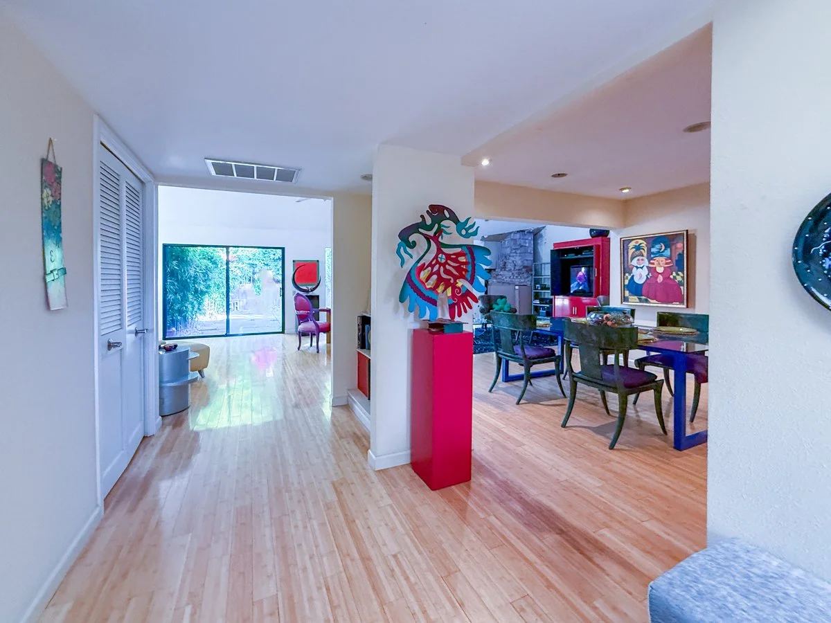 From entry way a view to the living room, back patio and dining area. 