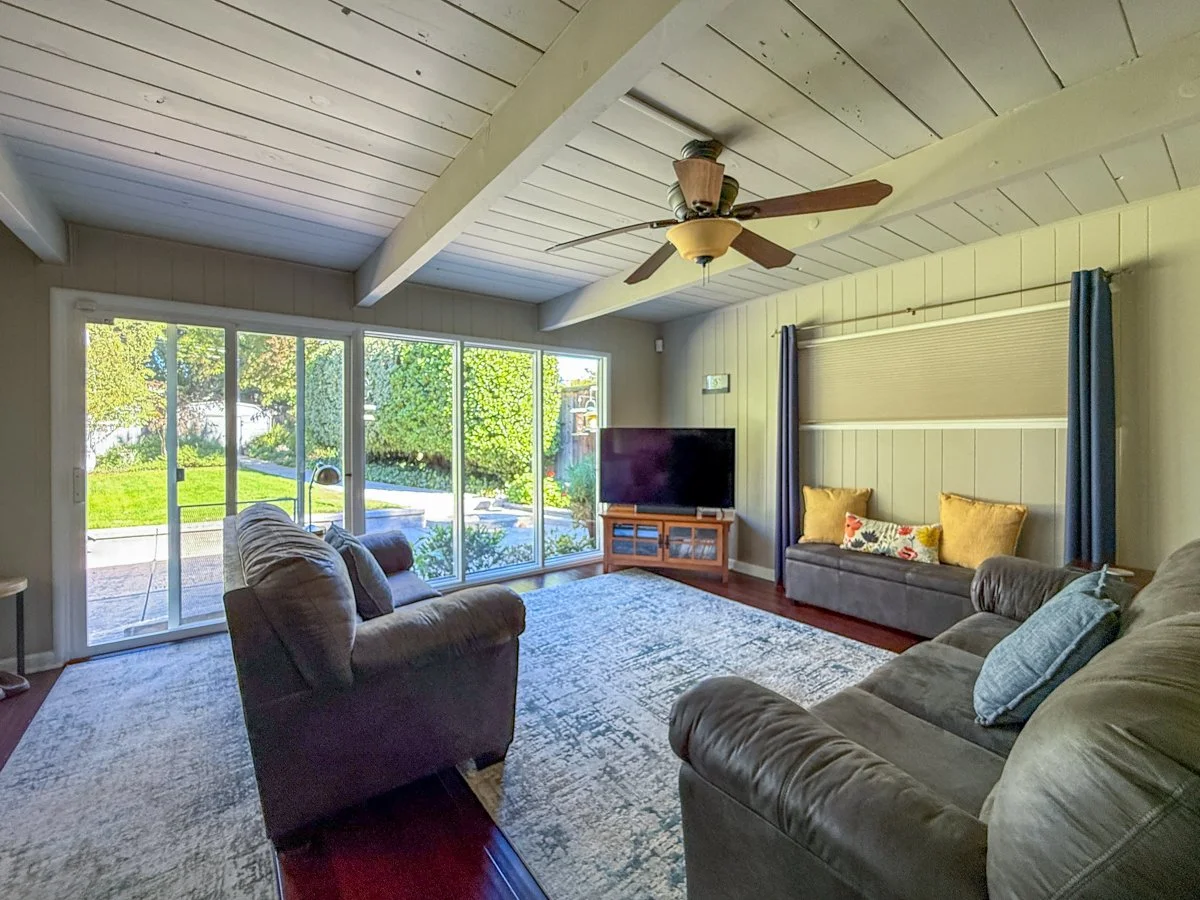 Family room with vaulted, open beam ceilings and view to back yard.
