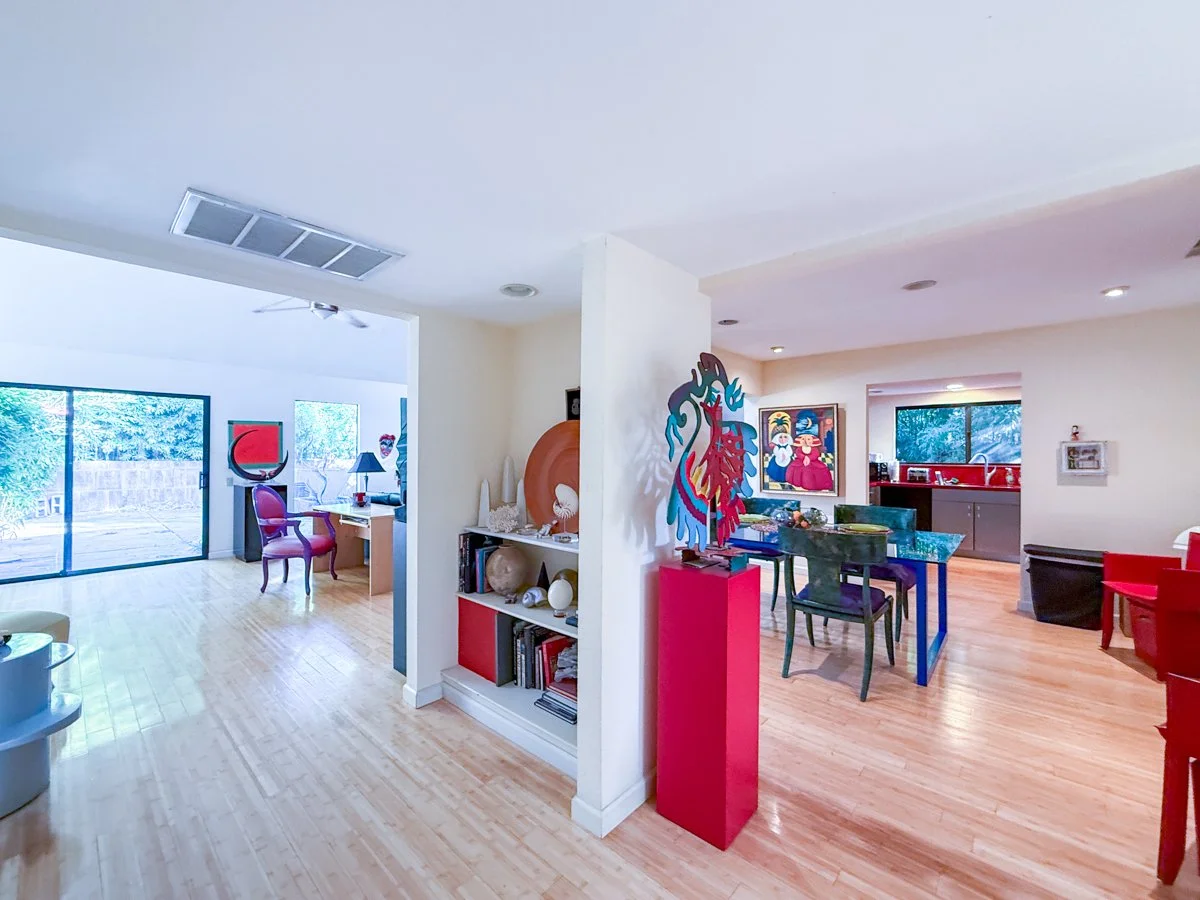 From entry way a view to the living room, back patio and dining area. 