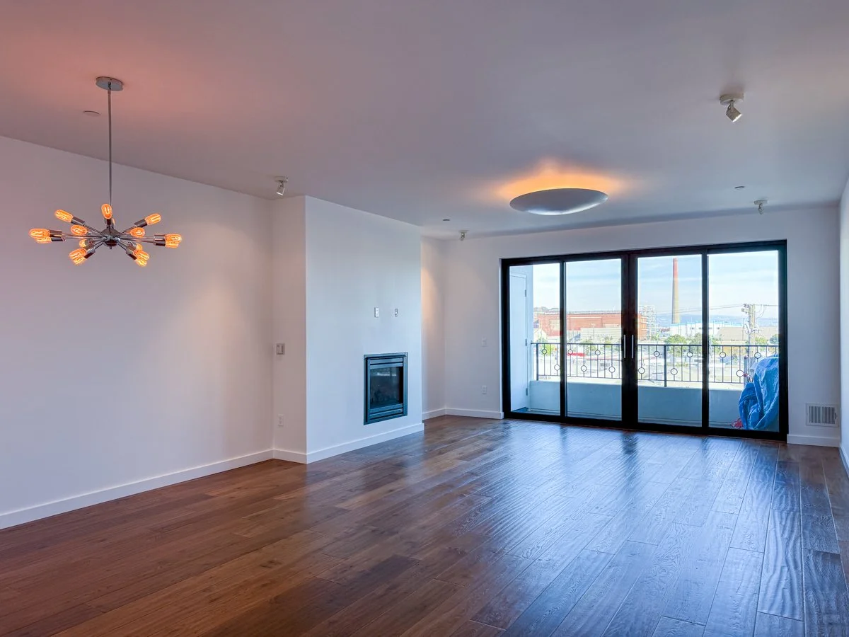 Spacious living room with wood floors and Bay View. 