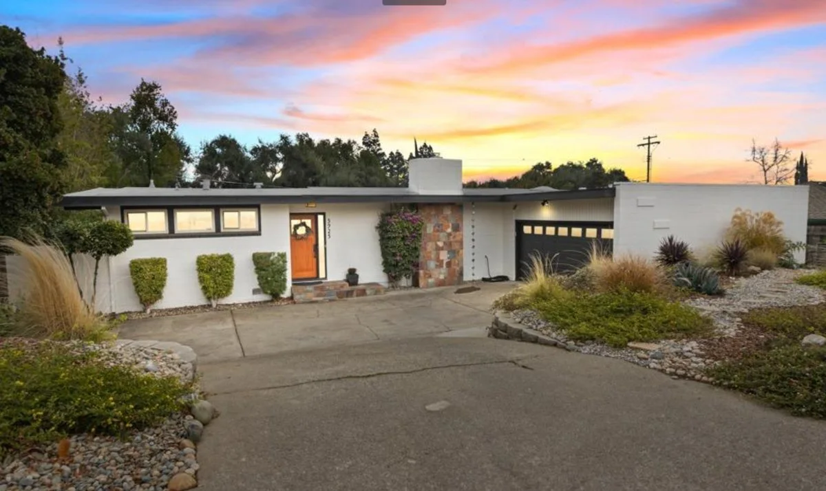 Flat Roofed mid century modern home with orange door.
