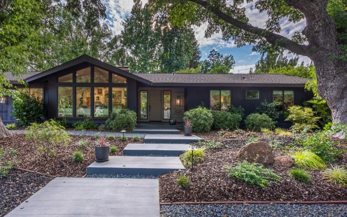 Stair stepped concrete squares make a walkway to a lovely mid century modern home.