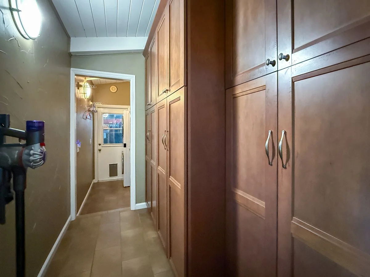 Plentiful cabinets in hallway to laundry room. 