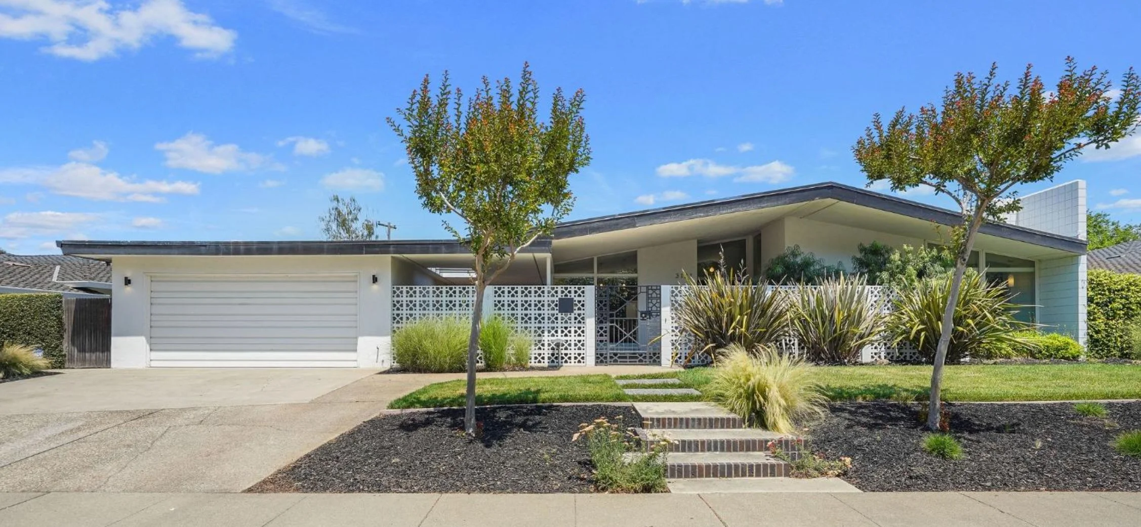 White mid century modern home with breeze block wall