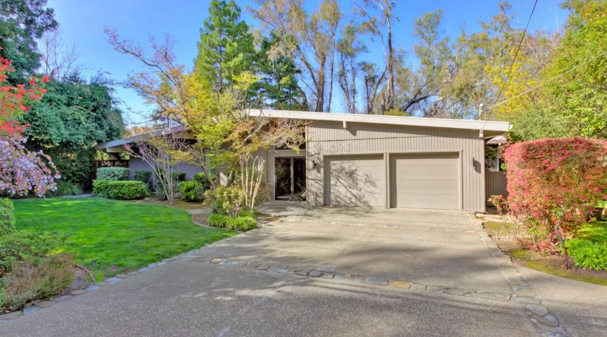 Gable roofed custom mid century modern home with 2 car garage.