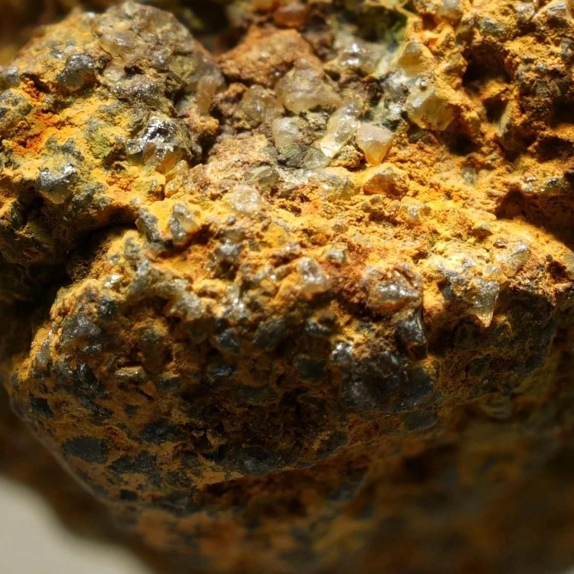 small uraninite uranium specimen in quartz matrix with iron oxide coating compact radioactive mineral sample