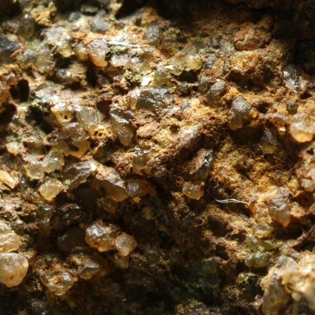 small uraninite uranium specimen in quartz matrix with iron oxide coating compact radioactive mineral sample