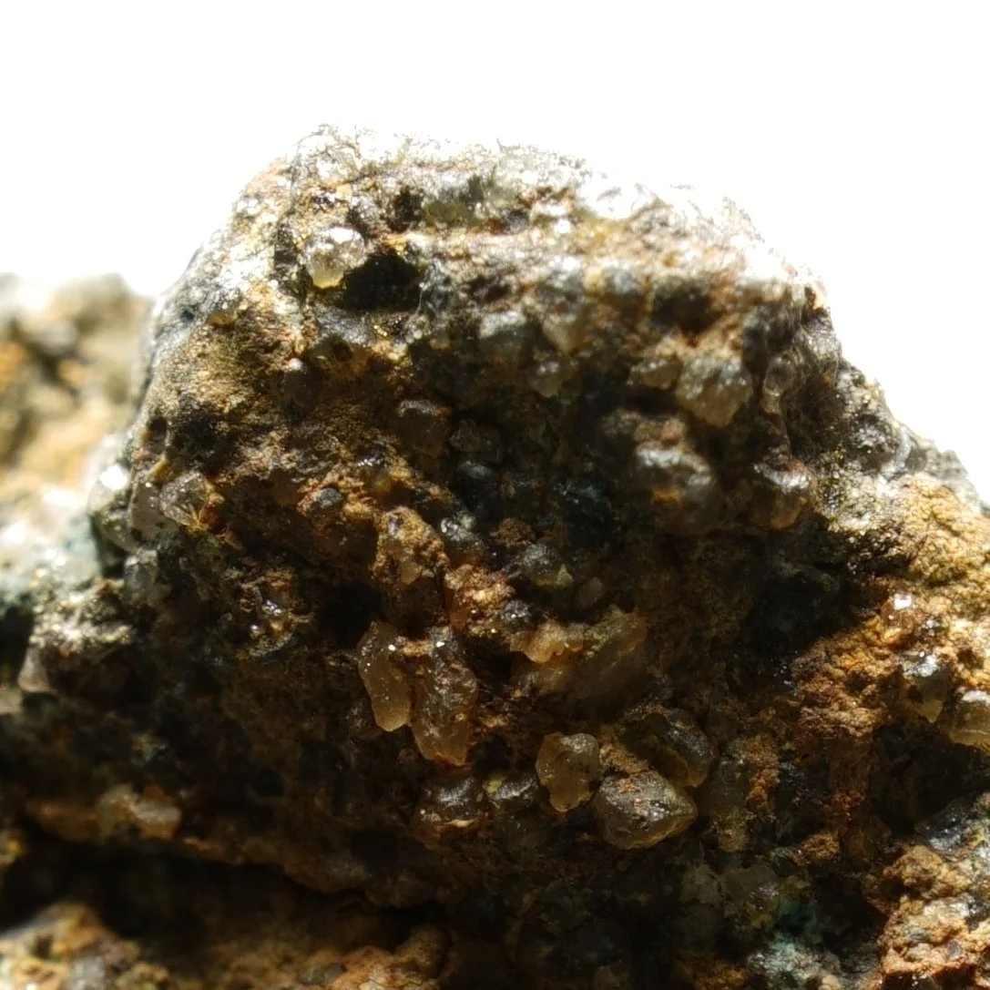 small uraninite uranium specimen in quartz matrix with iron oxide coating compact radioactive mineral sample