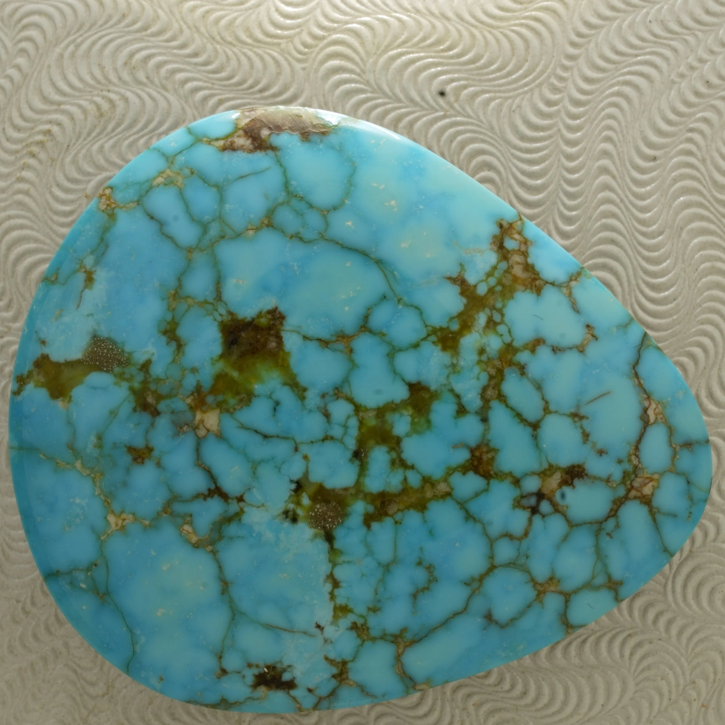 Large polished Kingman turquoise cabochon with bright blue color, brown matrix, black backing, stabilized and backed, 72.5 carats.