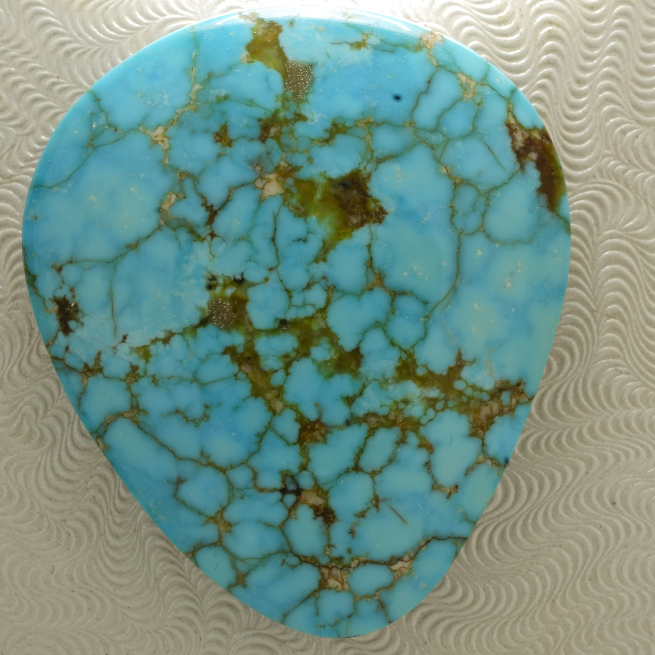 Large polished Kingman turquoise cabochon with bright blue color, brown matrix, black backing, stabilized and backed, 72.5 carats.