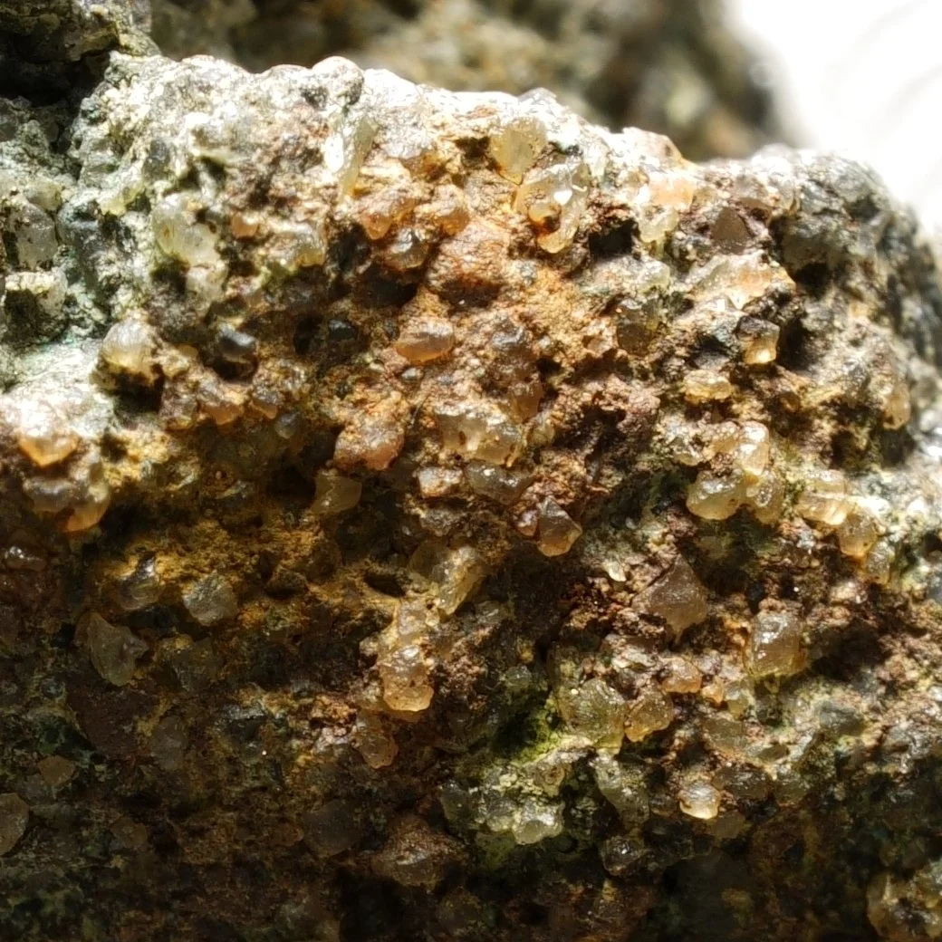 small uraninite uranium specimen in quartz matrix with iron oxide coating compact radioactive mineral sample