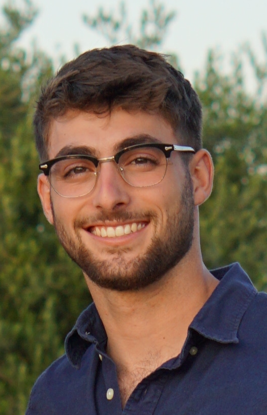 A ripe cucumber growing on a vine inside a greenhouse.