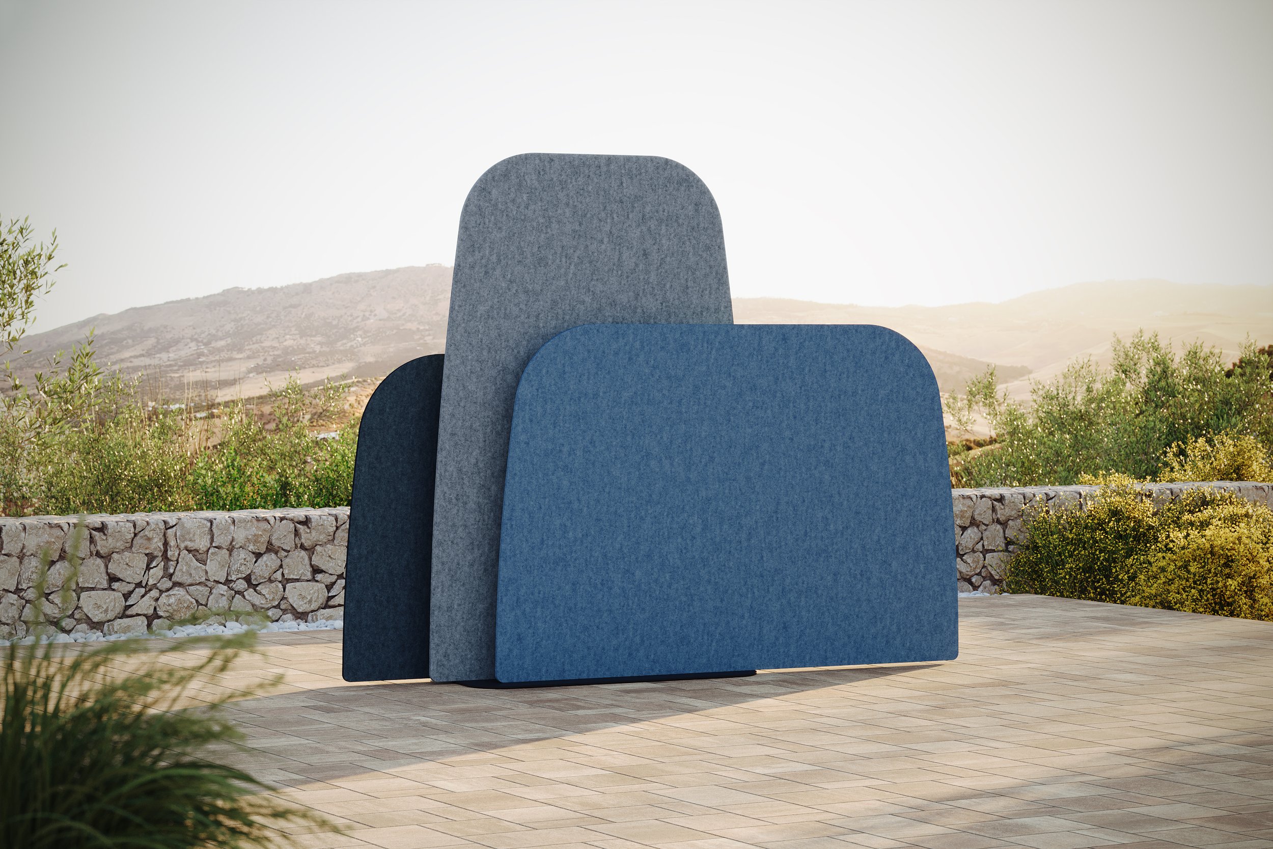 Three GiosFelt Landscape layered screen dividers in shades of blue and gray on a patio with a mountain and shrub landscape in the background.
