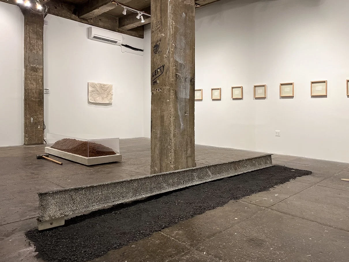 gallery with I-beam on floor and art on walls