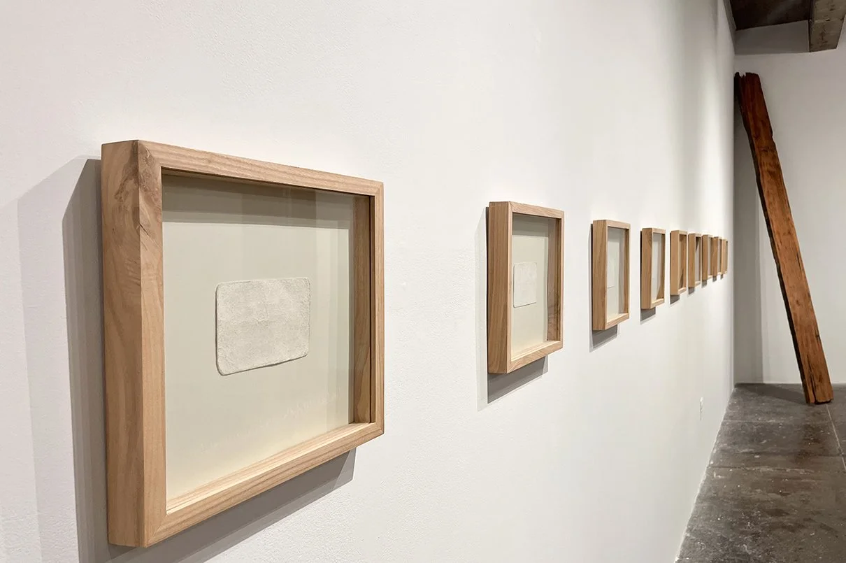 Close up of row of framed paper works