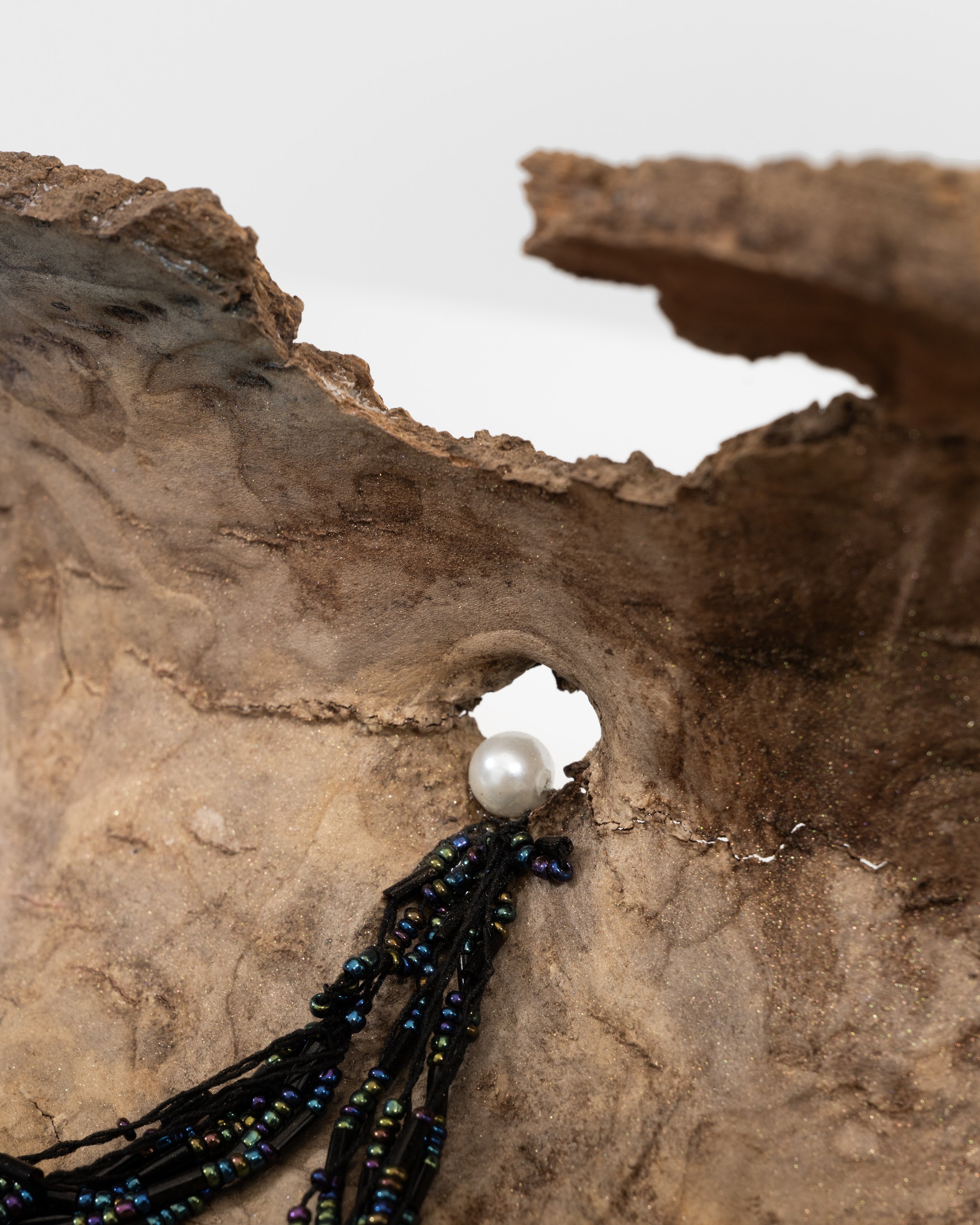 We Will Never Meet 
found tree bark, plastic pearl, beads, string, seashell, mica powder 
2021, 5" x 25" x 10" 