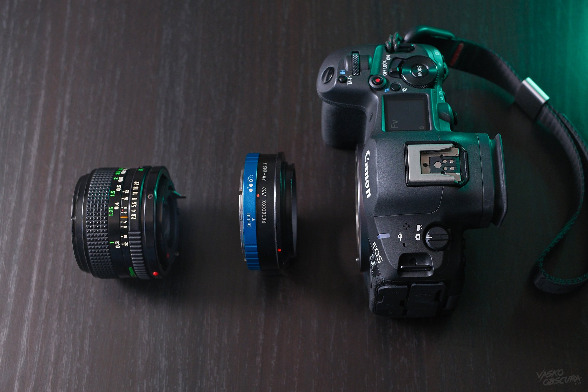 Image showing the process of mounting a vintage Canon nFD lens onto a modern Canon mirrorless camera.