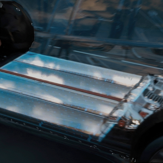 Close-up of a futuristic metallic surface with reflections and parts of a vehicle or machinery.
