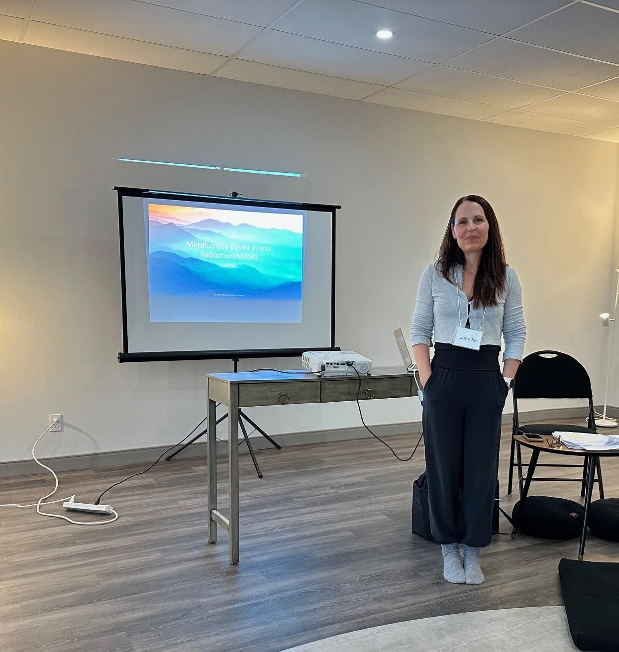 Woman presenting a Mindfulness-Based Stress Reduction slide in a conference room