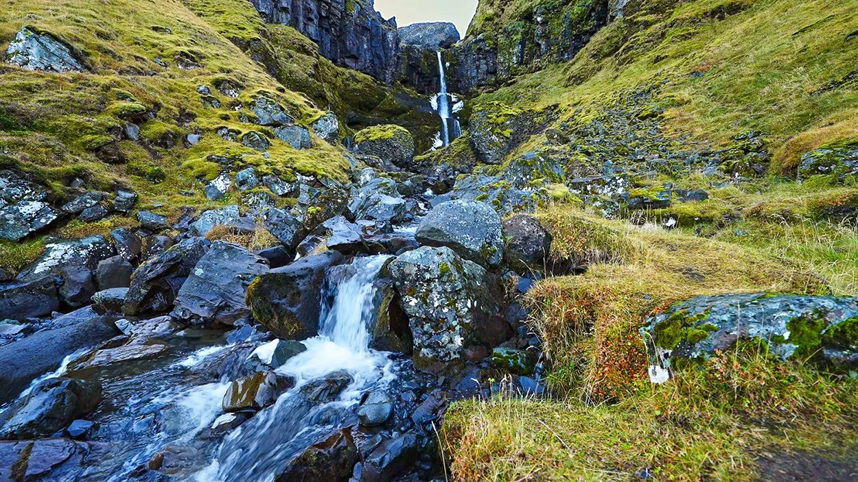 Iceland waterfall above a rocky mountain stream, featured in Weightless Moments, a 3-hour calming piano video by Dean Best.