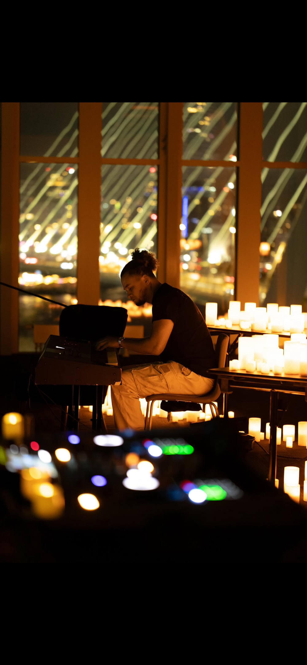 Pianist playing beside the window, city lights beyond