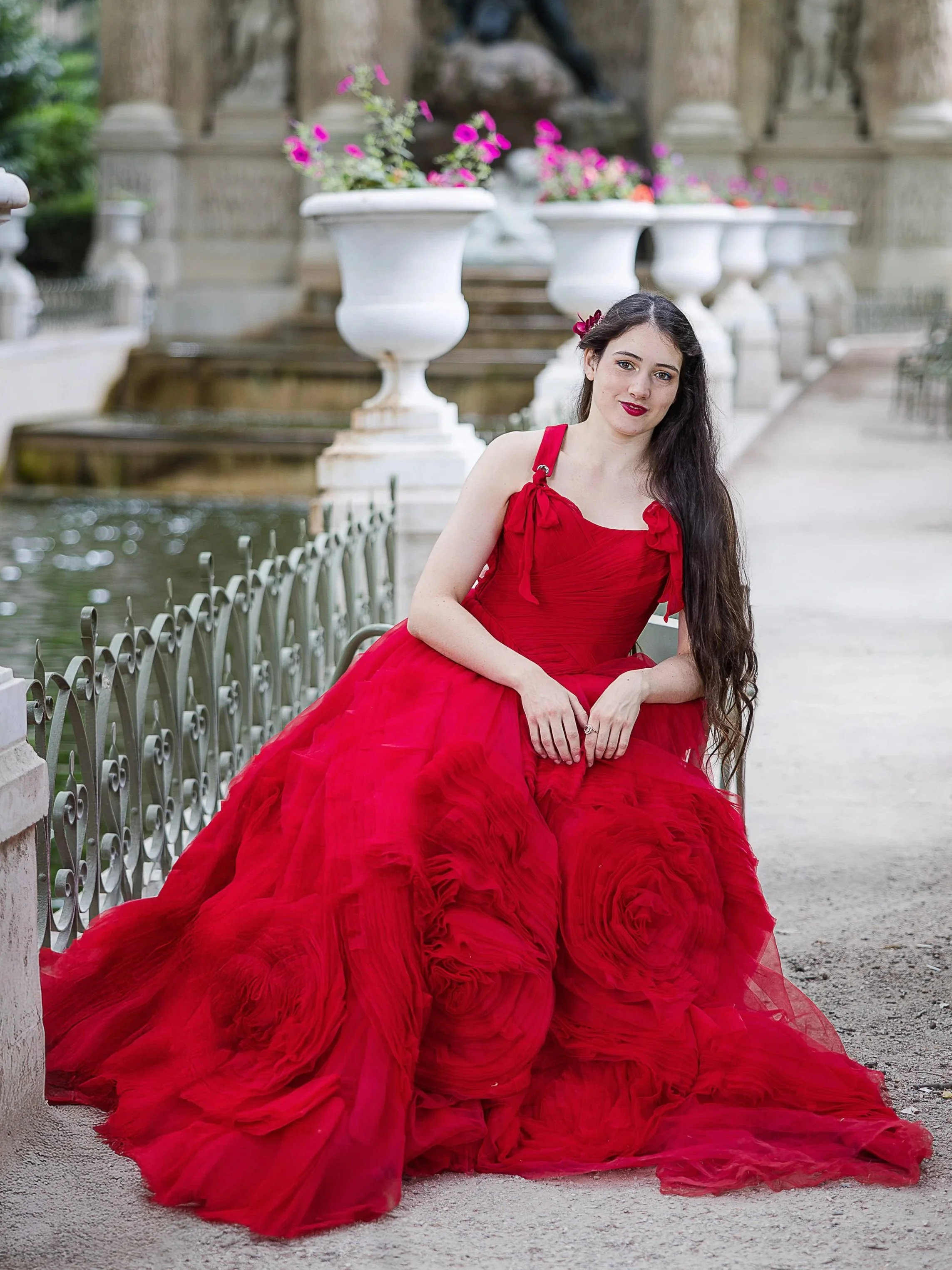 Natural light portrait of a young woman in a red dress at the Luxembourg Gardens in Paris