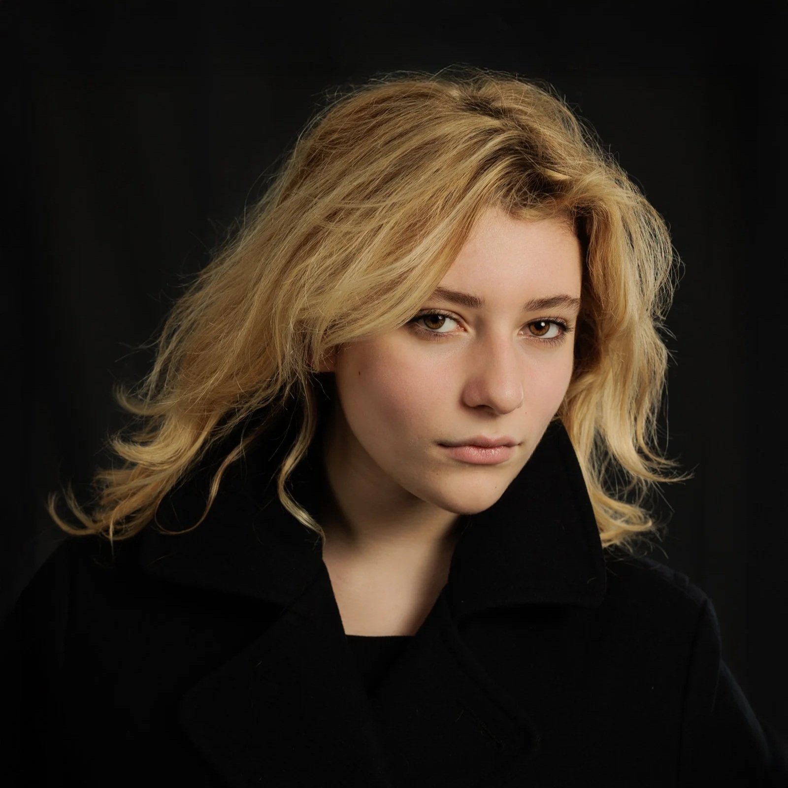Studio portrait of actress Hannah Castel-Chiche, photographed in Paris with soft directional lighting against a dark background.