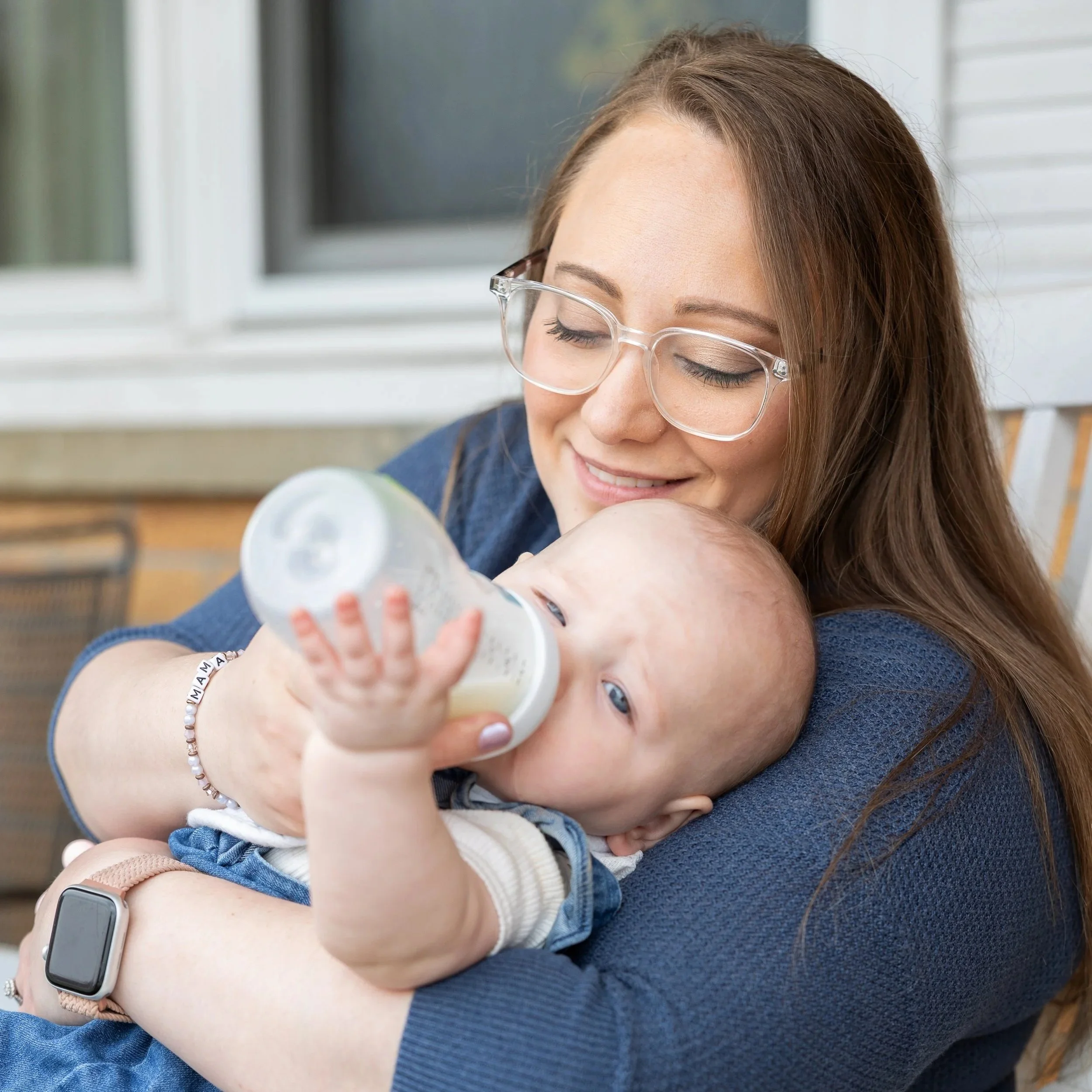 Mother bottle-feeding her baby during a natural family portrait session in Paris