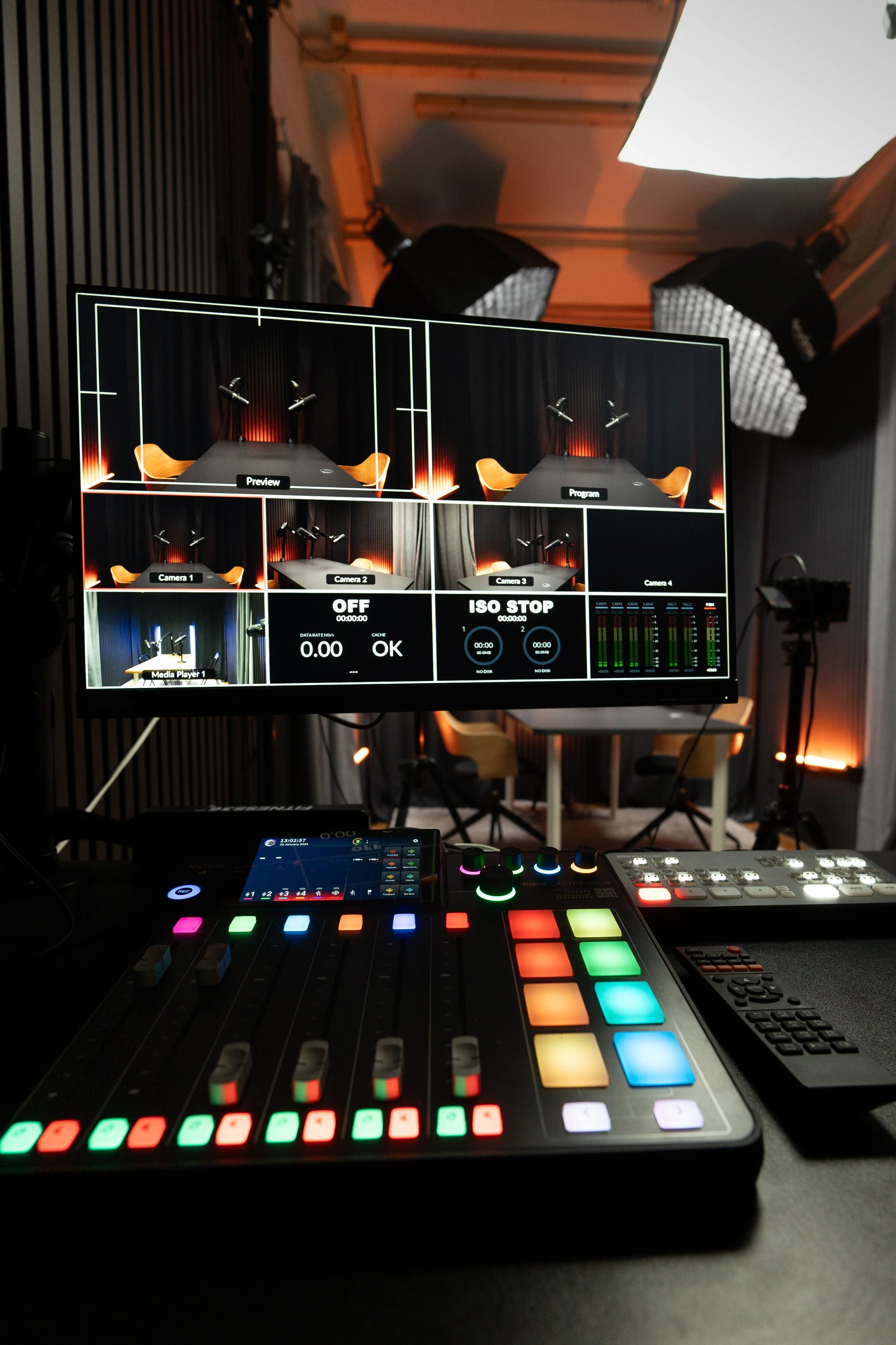 Video podcast studie med mikserekonsol, monitor med flere kameravisninger og studielamper.